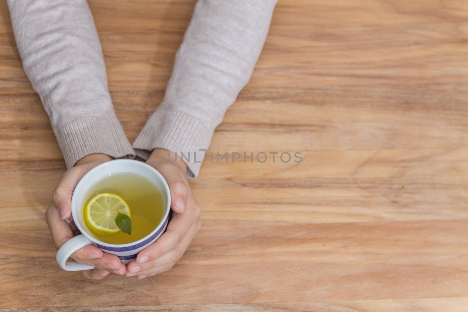 Hands holding a healthy hot tea for the flu by leo_de_la_garza
