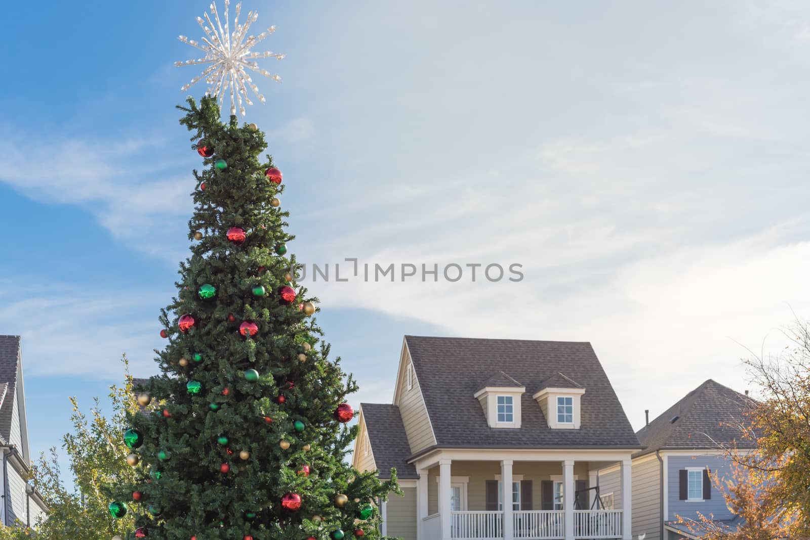 Christmas tree with snowflake tree topper and colorful glass ornaments balls at daytime by trongnguyen