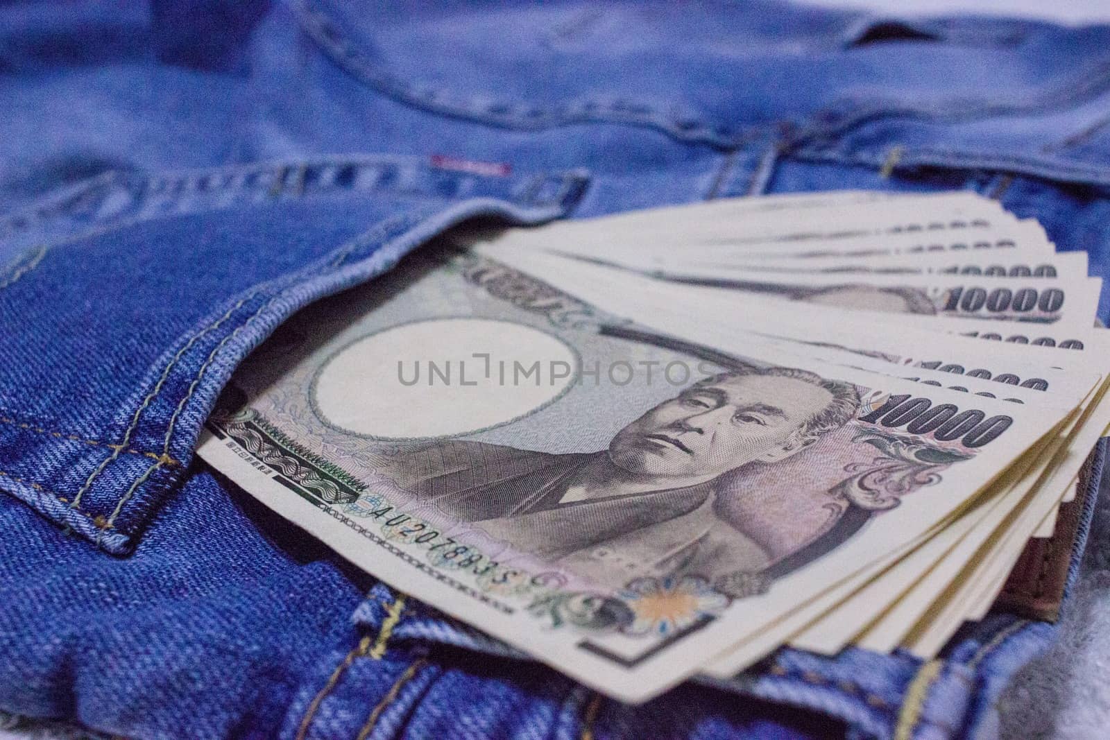 Japanese bank notes in pocket of jeans. by blueandrew8000@hotmail.com
