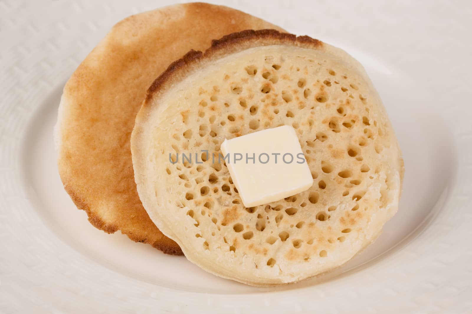 Delicious fresh British crumpets with butter by lanalanglois