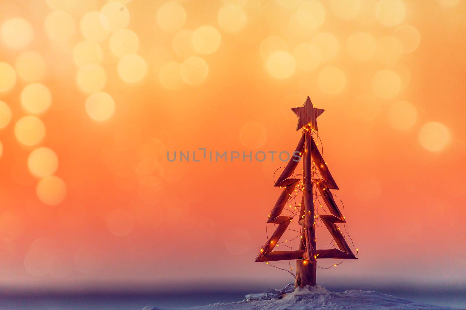 A Christmas by the beach.  Simple timber Christmas tree on a sandy beach.  
Summer Christmas holiday background ready for copy text