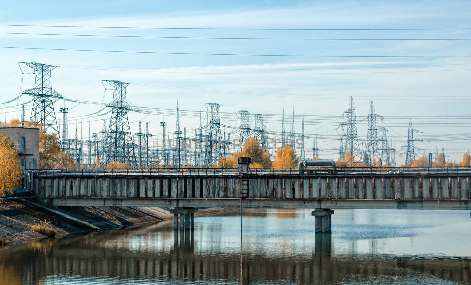 bridge over the river and power lines against the sky and clouds in Chernobyl Ukraine in autumn