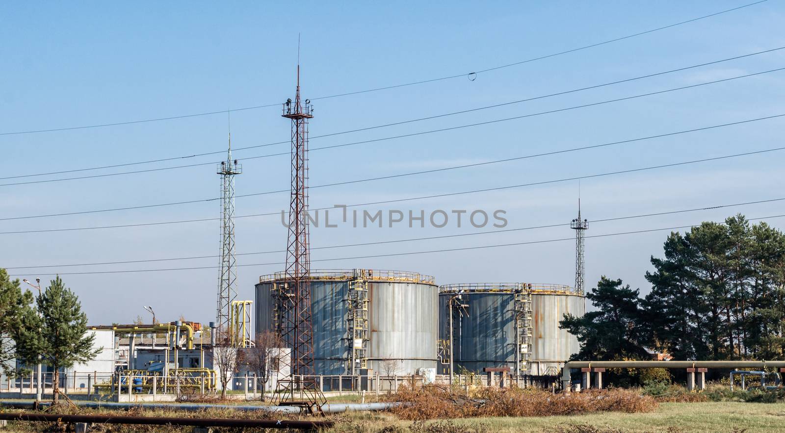 storage tanks of nuclear waste among green trees against a blue sky in Chernobyl Ukraine in the fall afternoon
