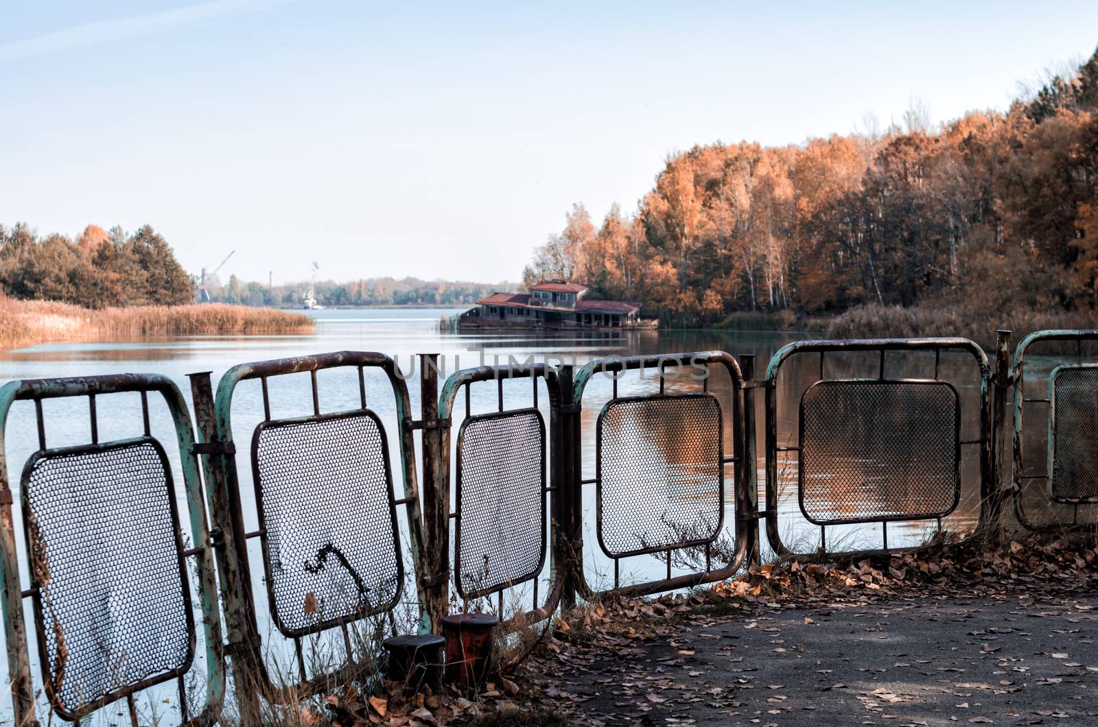 autumn landscape river and pier with a sunken destroyed house in Chernobyl in Ukraine