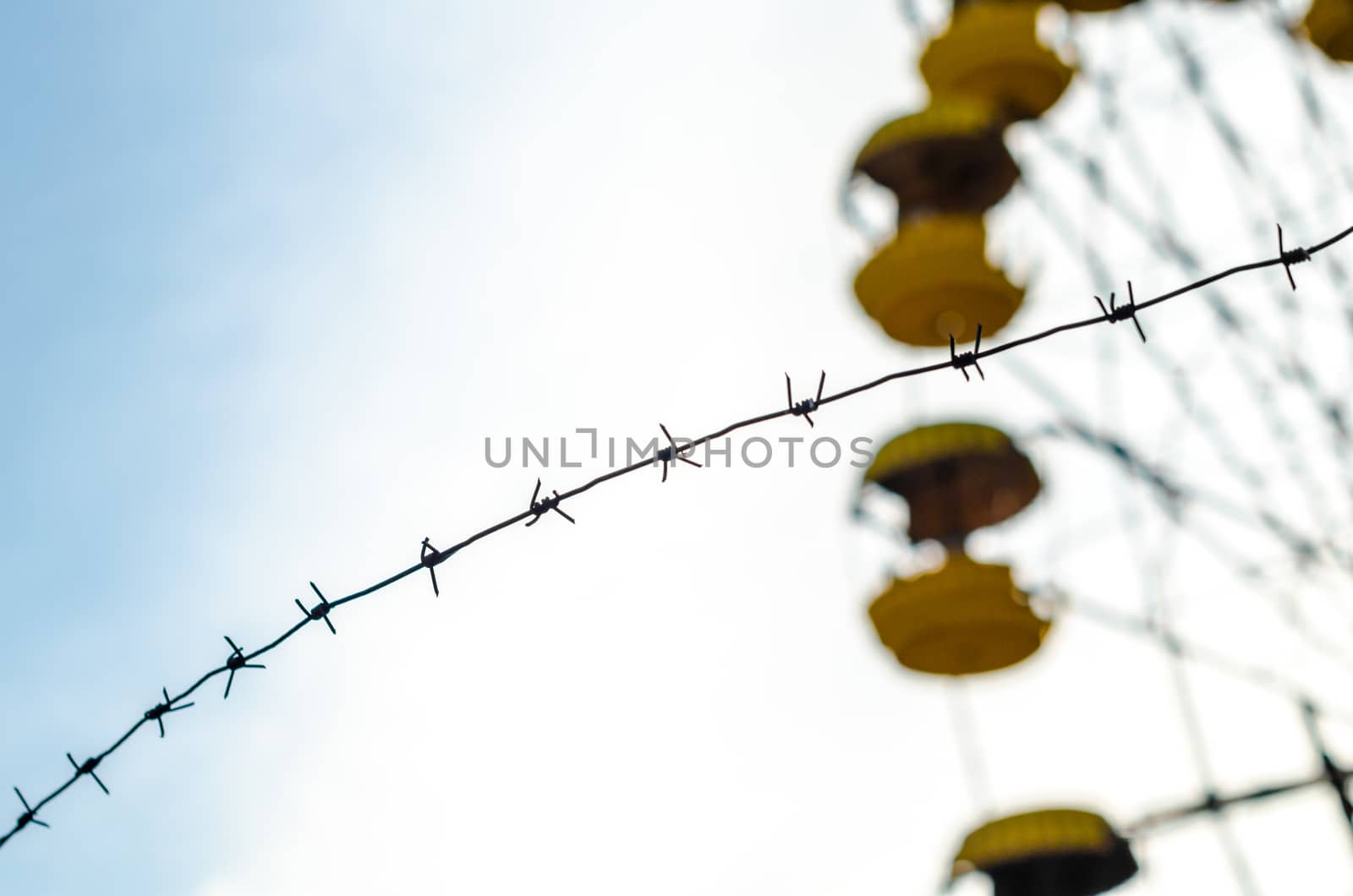 barbed wire and cabins carousel wheel in an abandoned amusement park in Chernobyl Ukraine in autumn