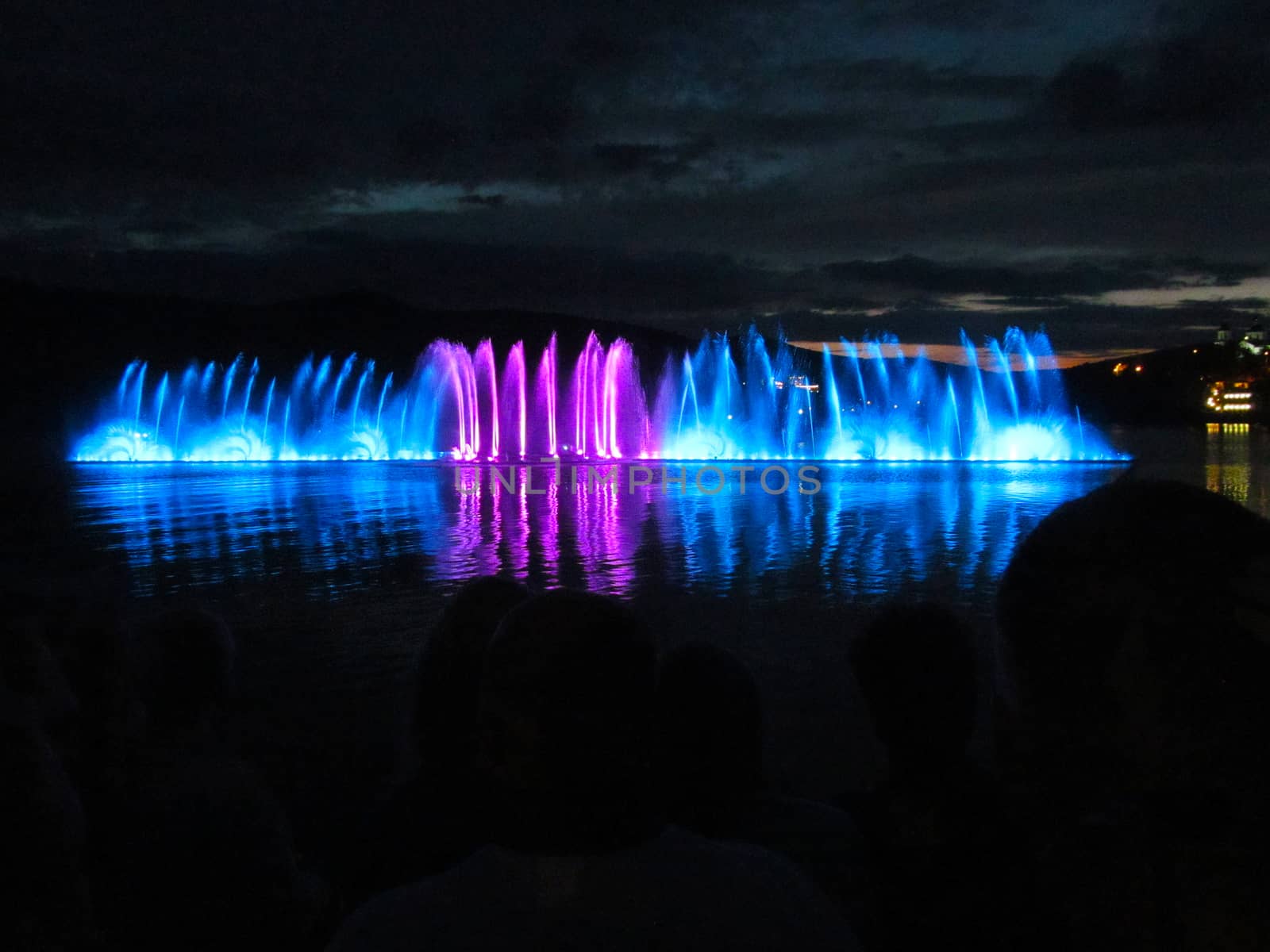 
Fountains of blue and crimson at night over the water. by Igor2006