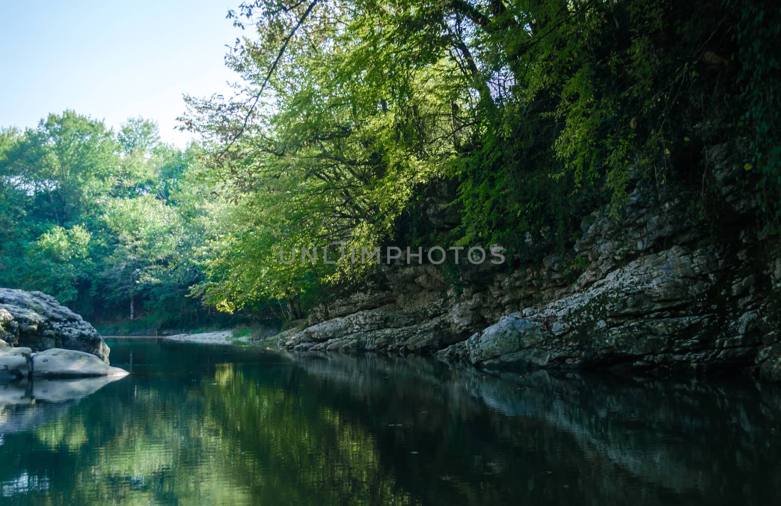 rocky shore of a mountain river and green trees in Martville Canyon in Georgia in autumn