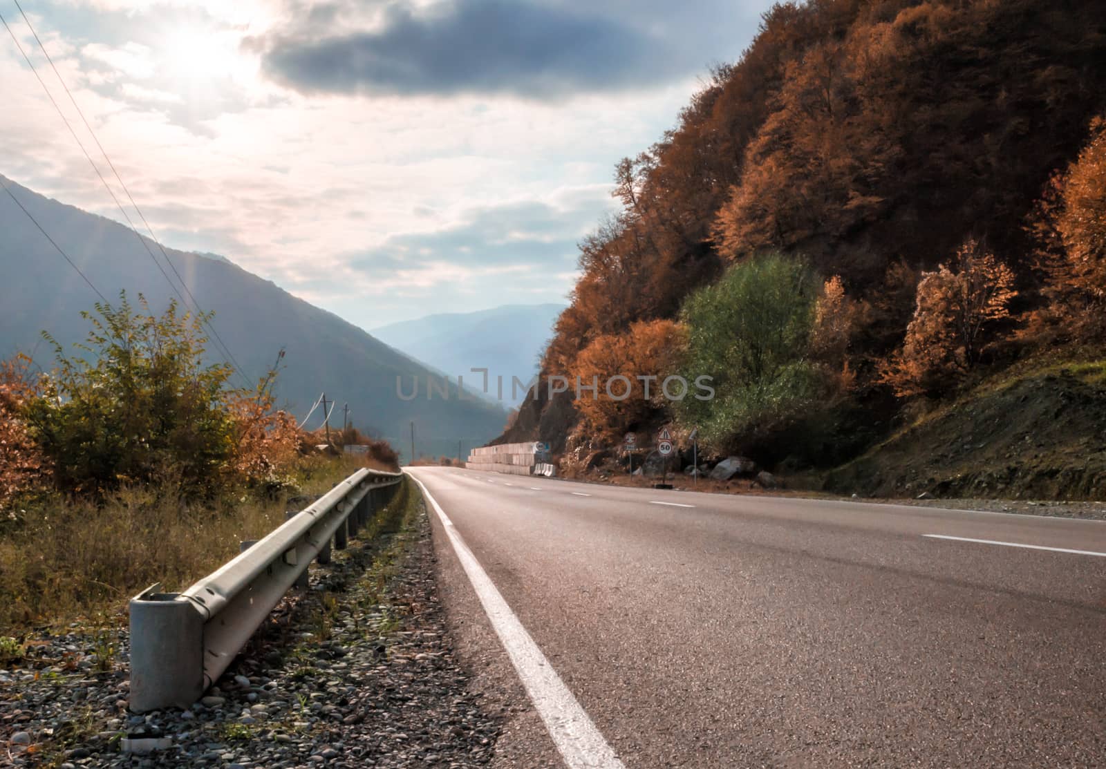 landscape mountain road and sky with sunbeams and clouds in Georgia in autumn