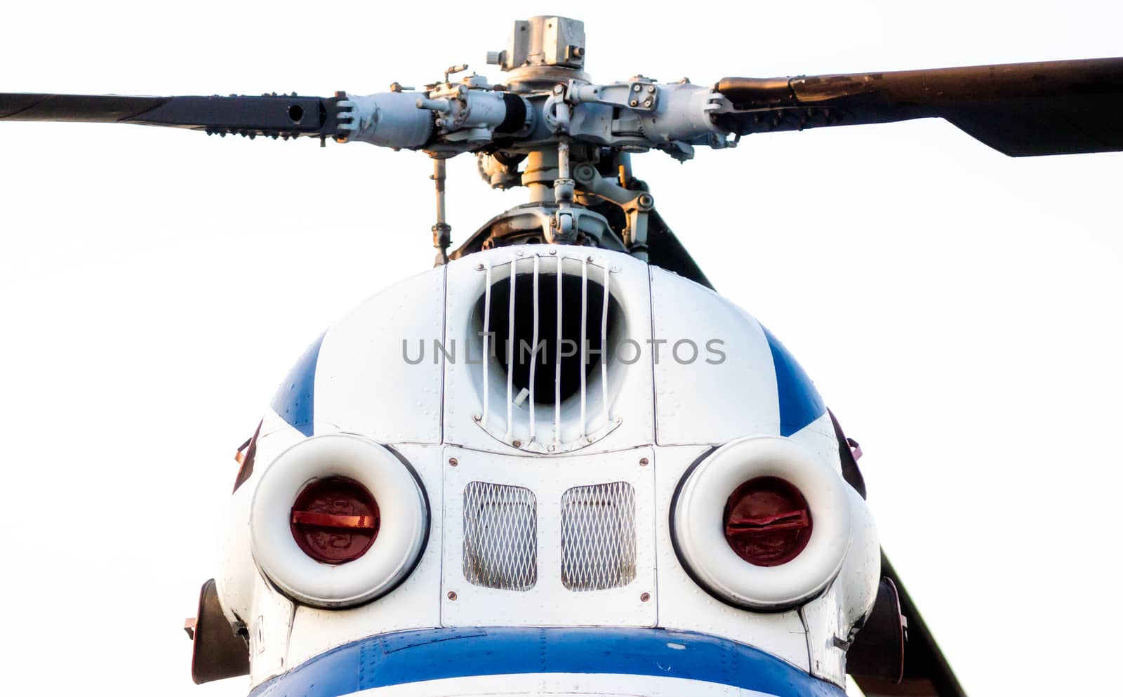 cockpit of an old white helicopter with propeller blades isolated close up
