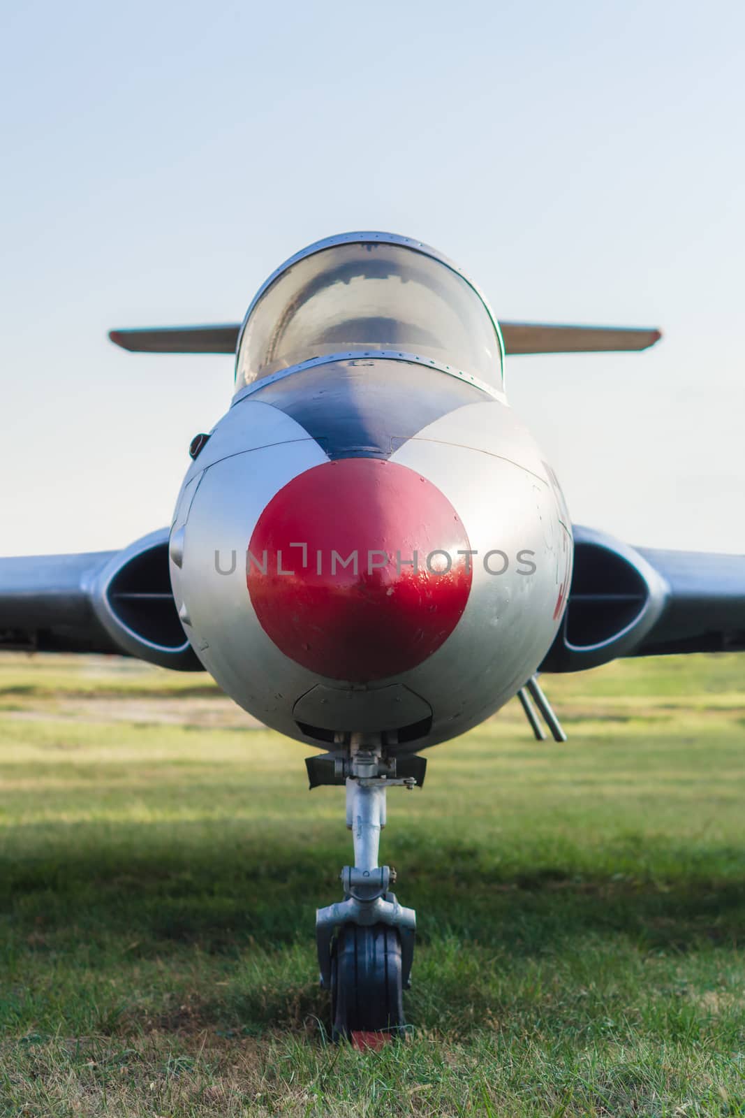 vintage sports plane on grass at the airport closeup on blue sky background