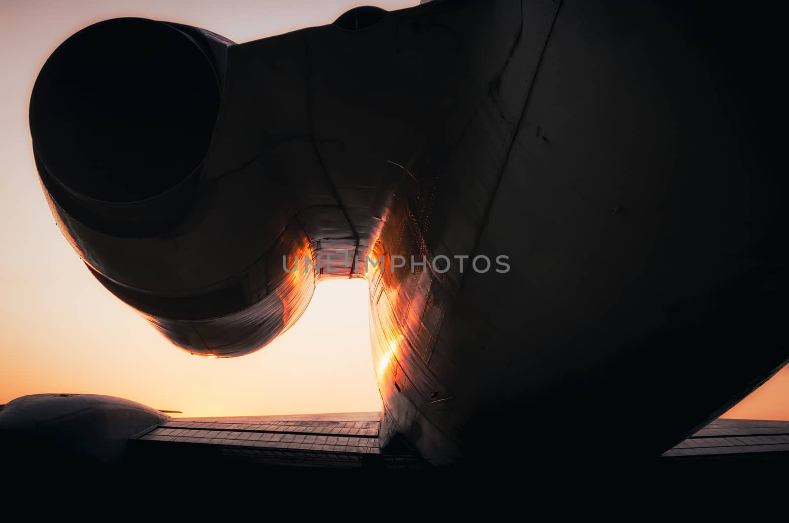 silhouette fragment turbine and wing of a large airliner on sunset background
