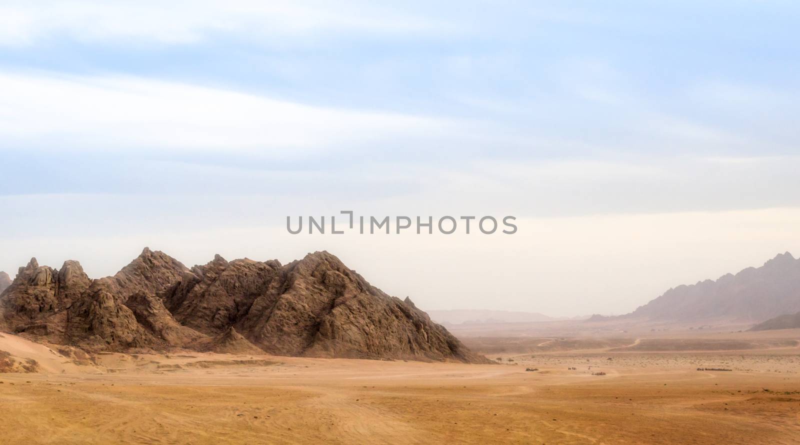 landscape of desert and high rocky mountains against the blue sk by Gera8th