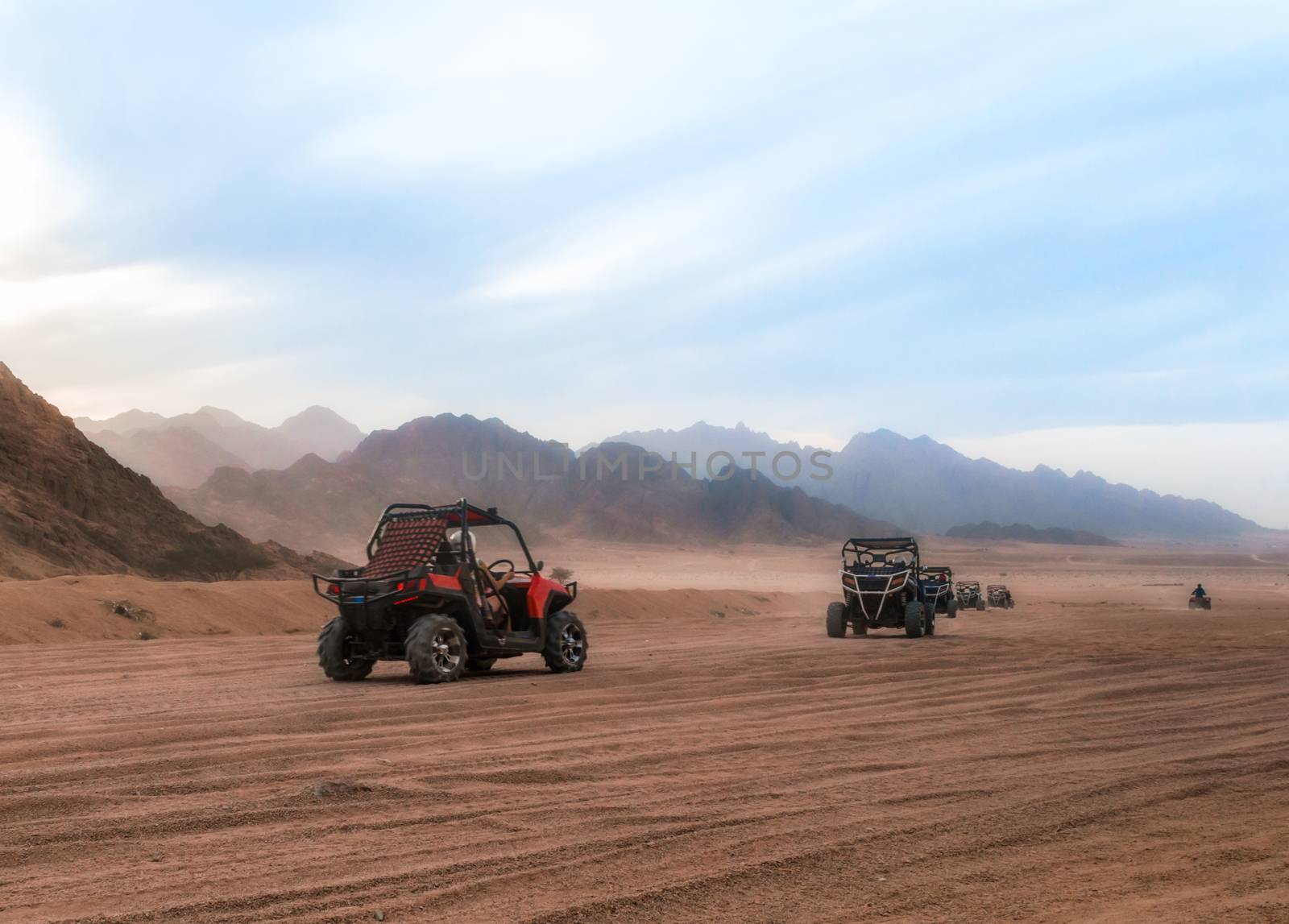 cars buggy with tourists on a trip through the desert with rocky mountains in Egypt in Sharm El Sheikh