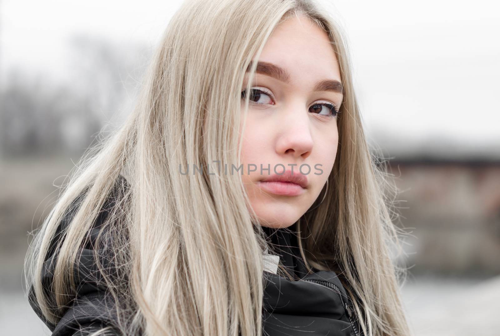 portrait of a young blonde girl in black clothes close up