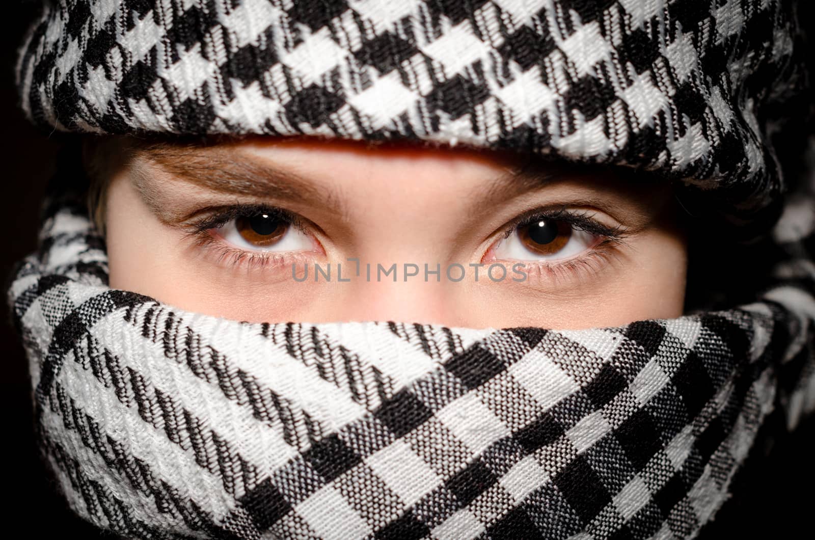 brown eyes of a young girl in arab black and white clothes close up