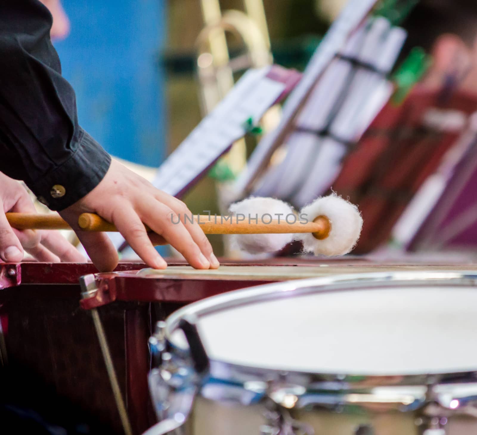 male musician drummer hands with drumsticks and drum closeup
