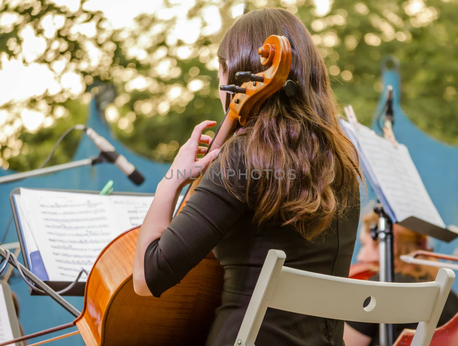 young brunette girl playing the cello on the street