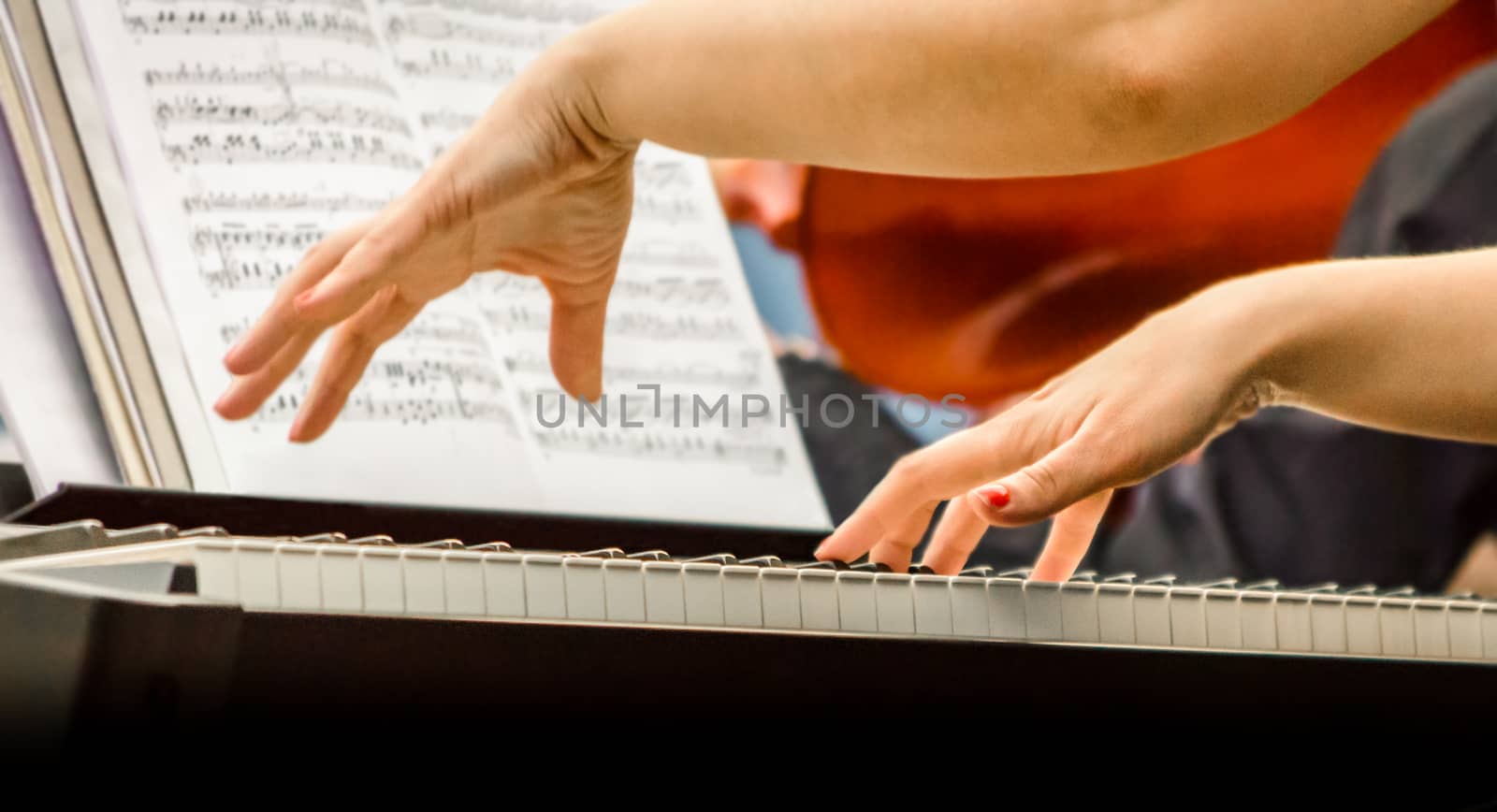 female hands of a pianist musician and piano keys closeup
