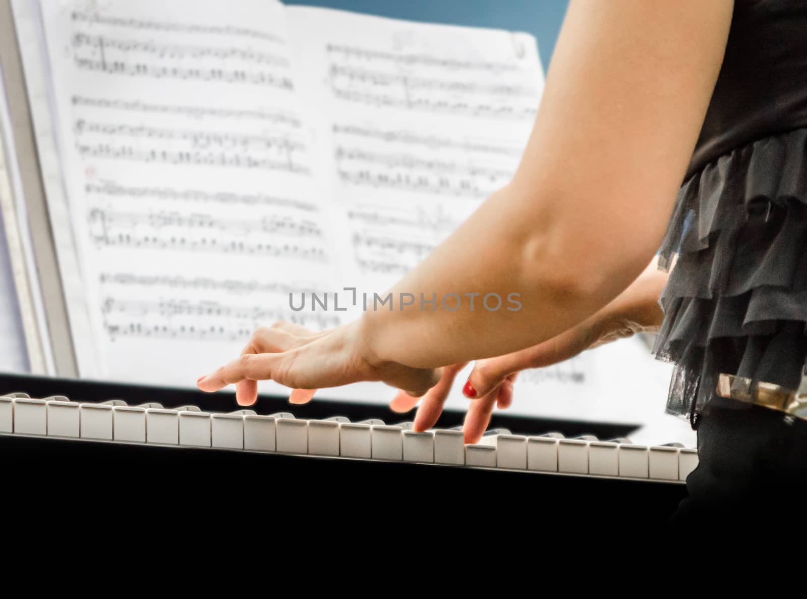female hands of a pianist musician and piano keys closeup