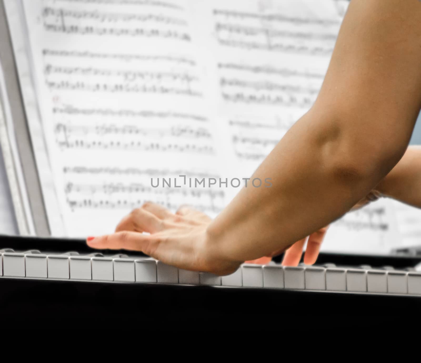 female hands of a pianist musician and piano keys closeup