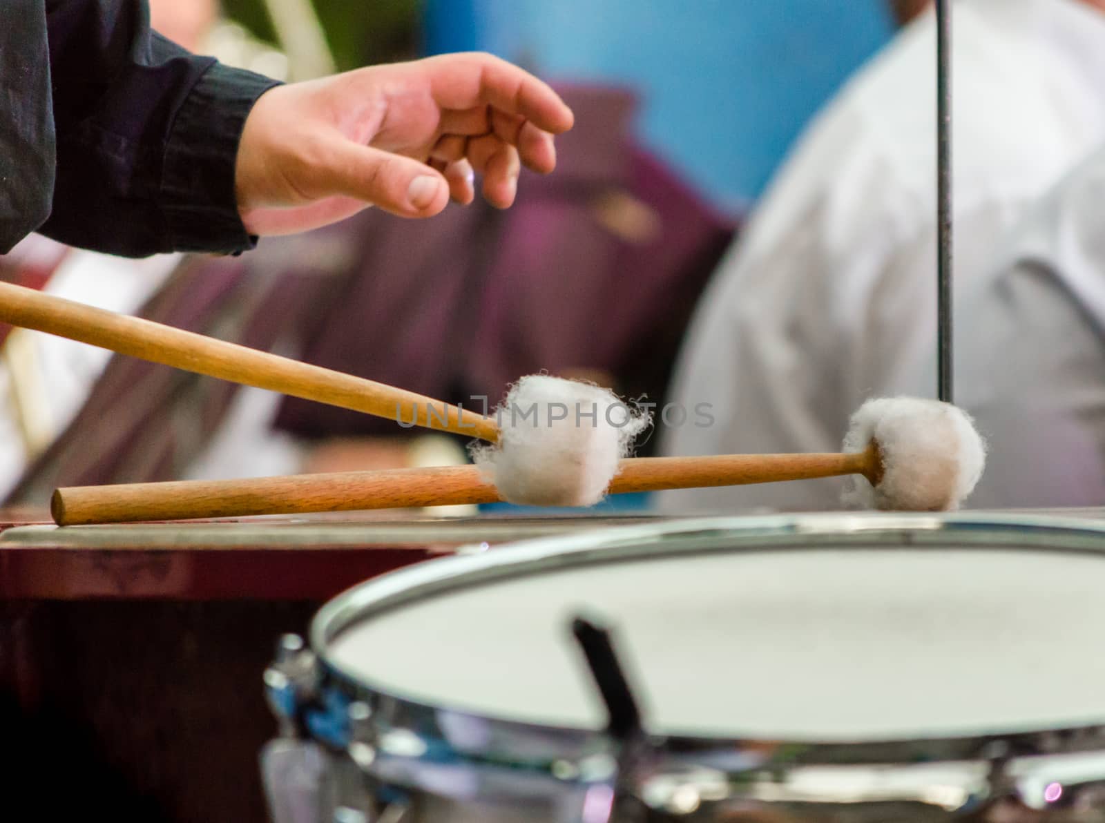 male musician drummer hand with drumsticks and drum closeup