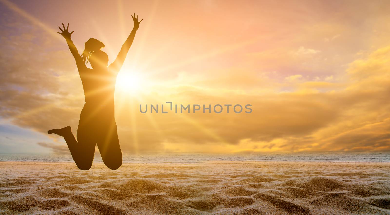 The girl is jumping with fun on the beach, the sea with the golden sun in the evening. summer concept by sarayut_thaneerat