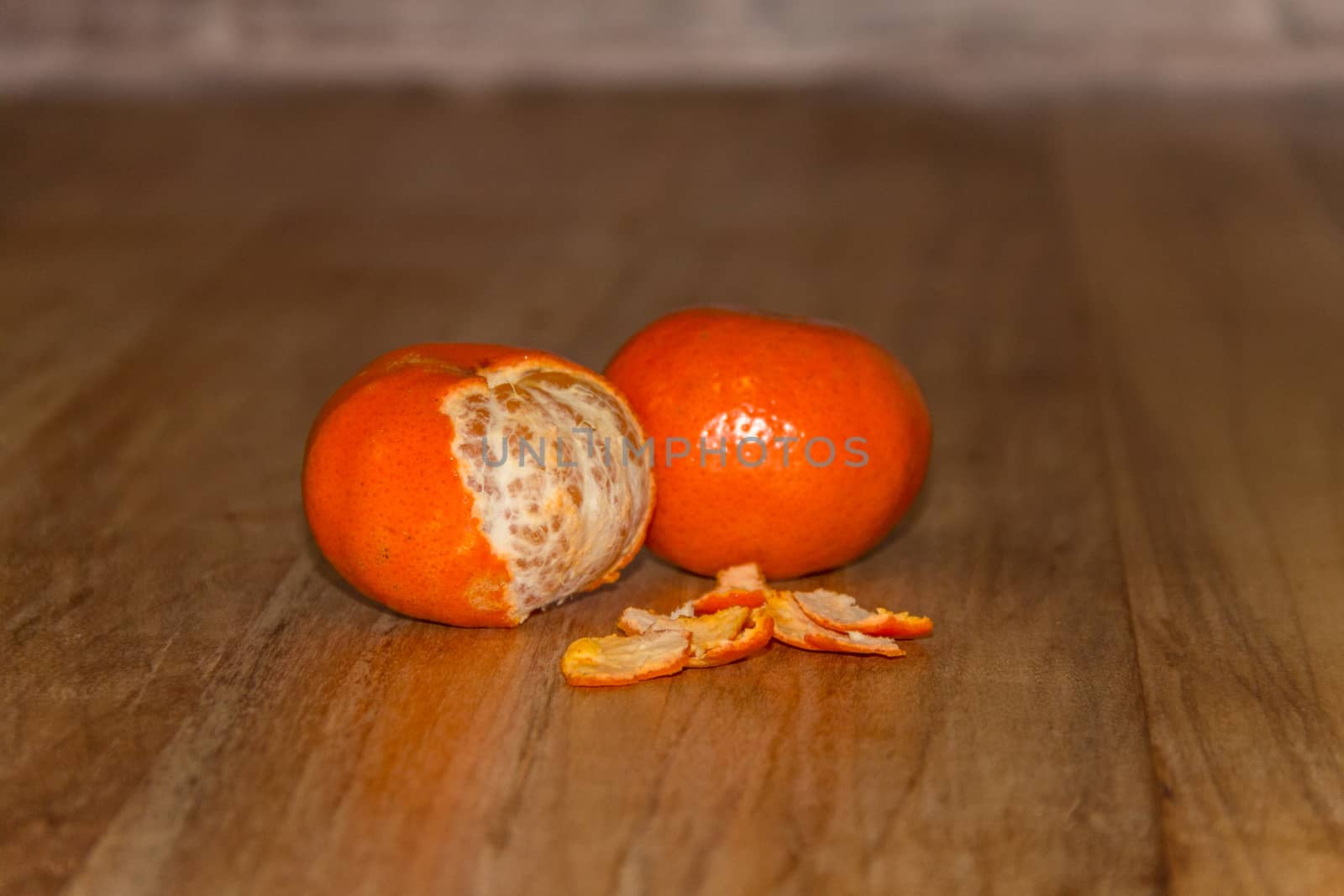 Orange colorful peeled tangerine over wooden table by leo_de_la_garza