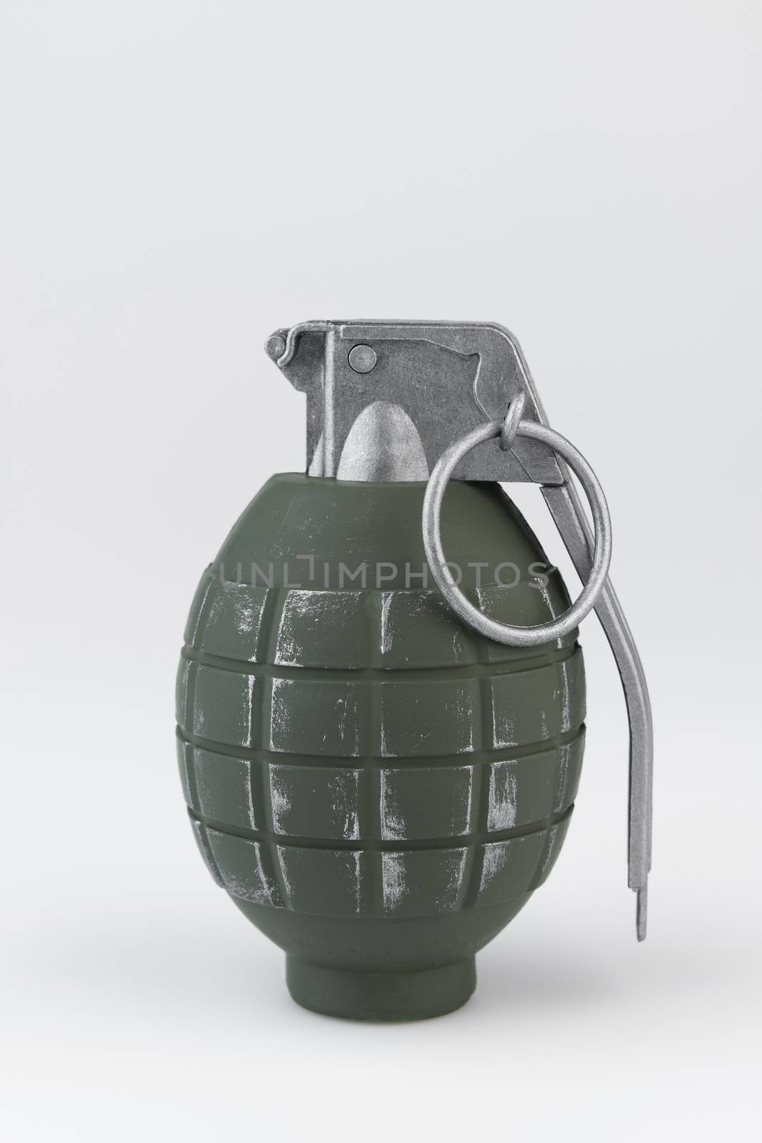 Green metal hand grenade against a white background
