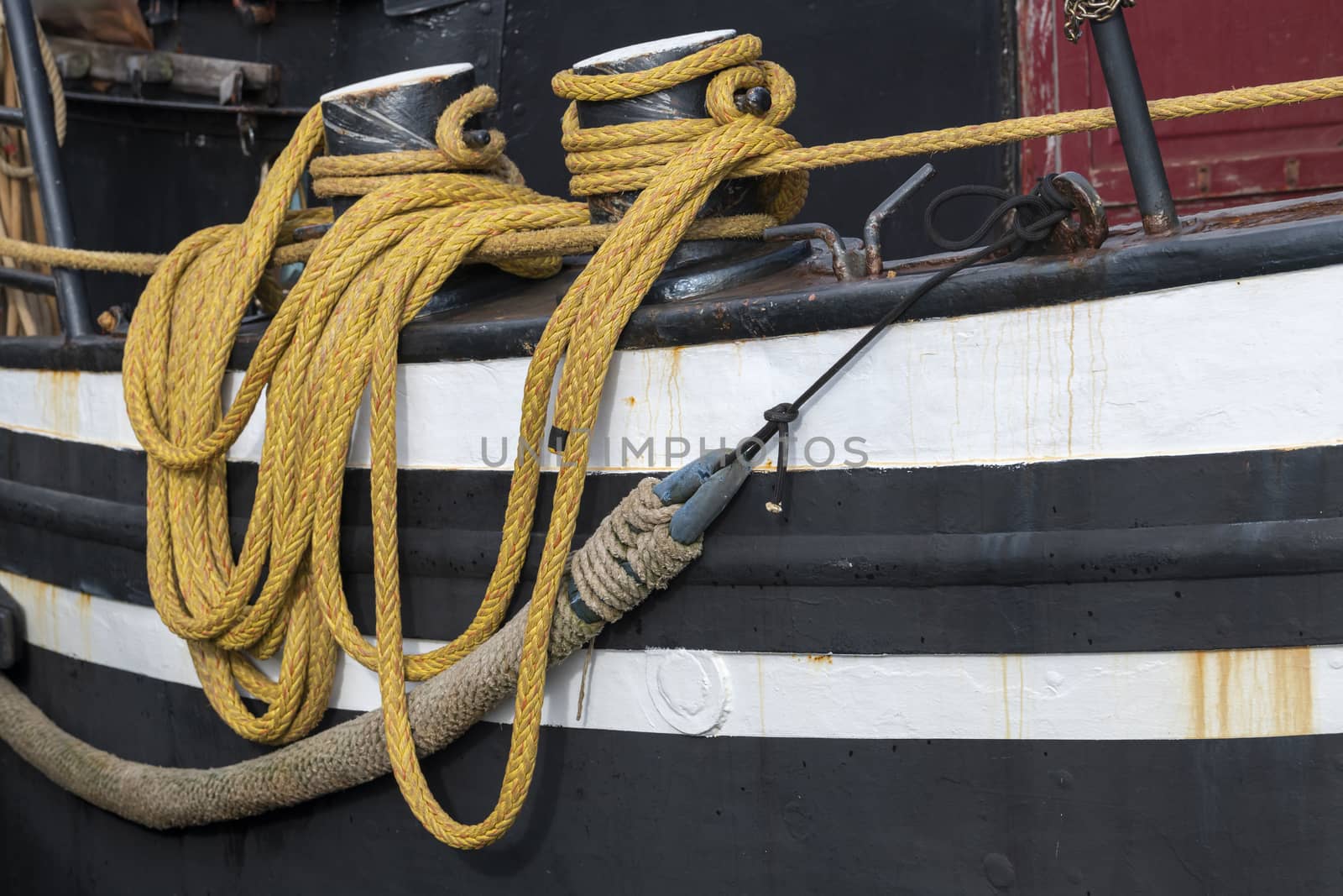 Yellow draped rope to a fishing boat in a harbour in the North of the Netherlands
