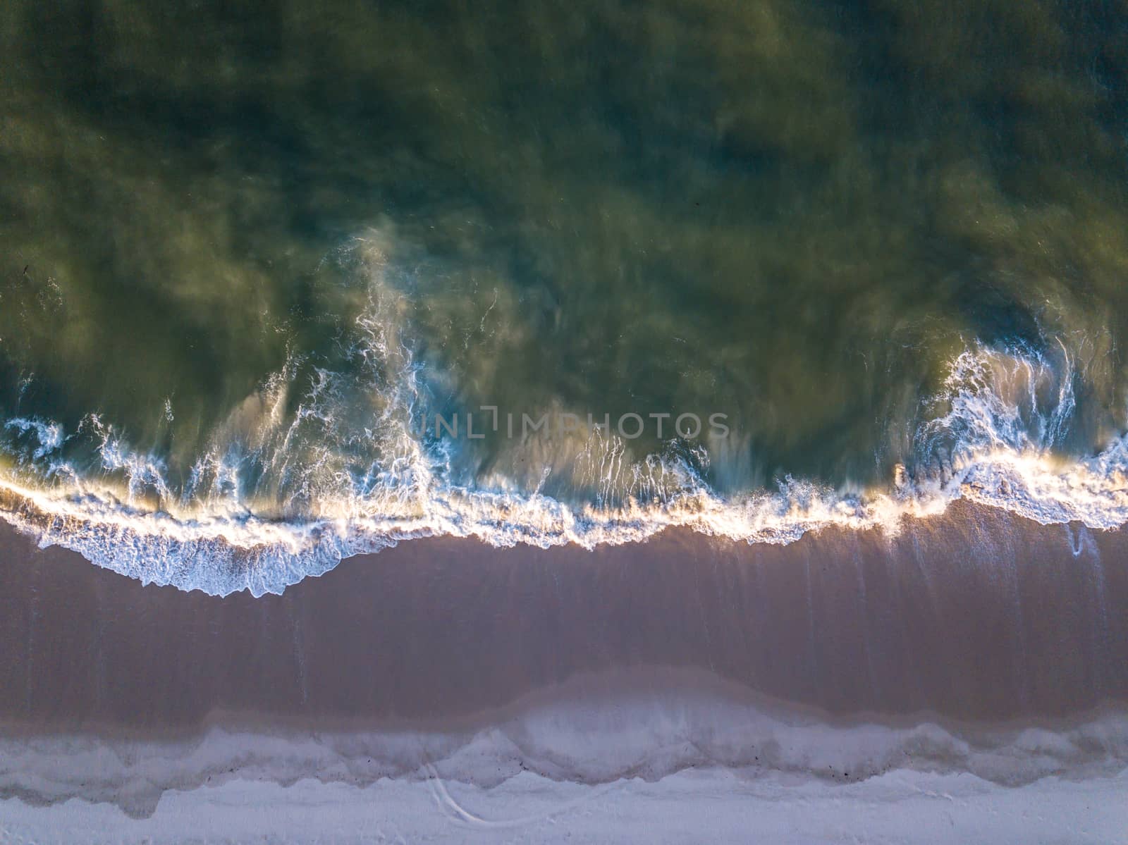 Drone picture of waves hitting the beach. by Simoneemanphotography