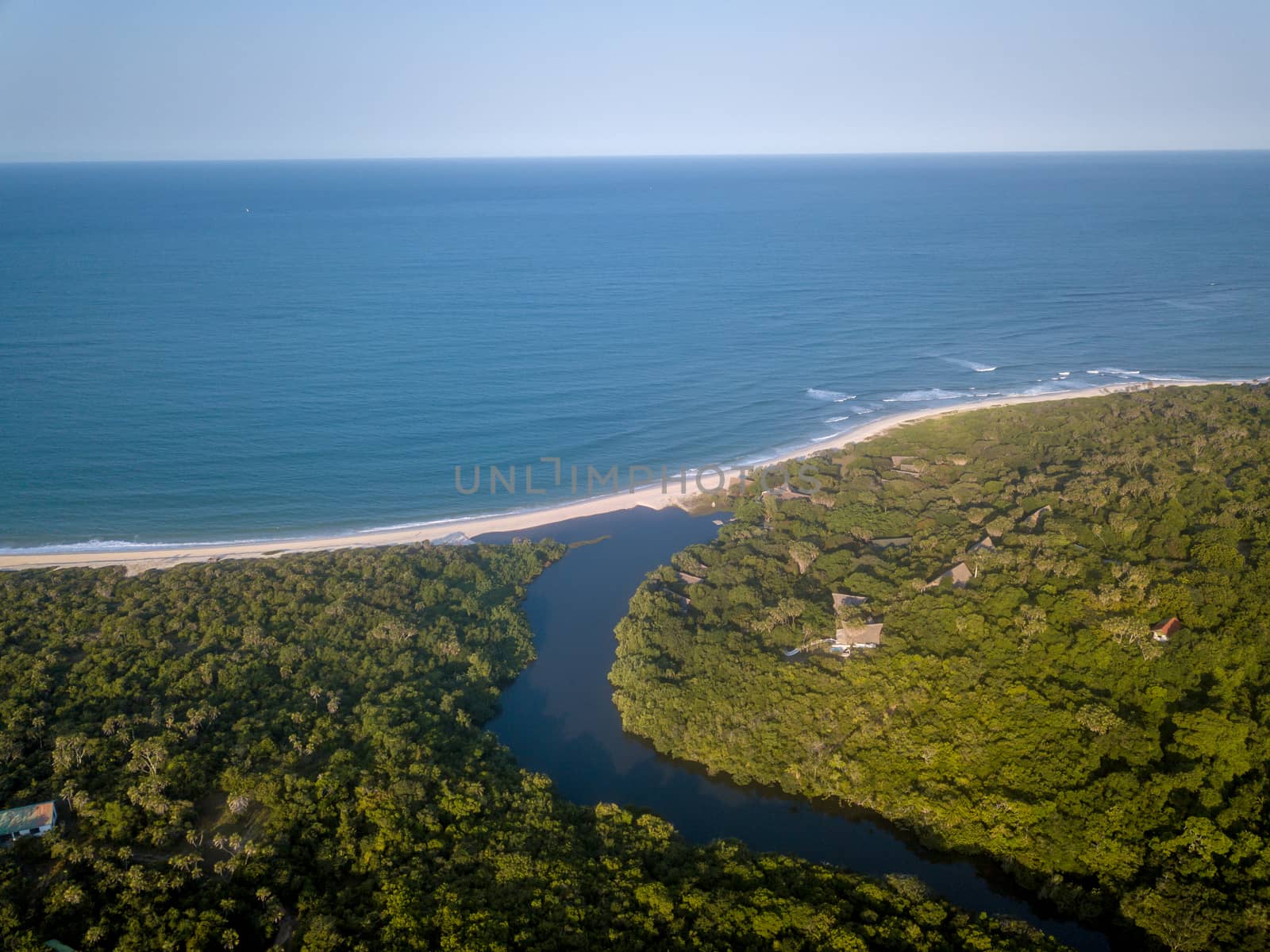 Drone picture of a lagoon in a coastal forest and the Indian ocean on the Swahili Coast, Tanzania.
