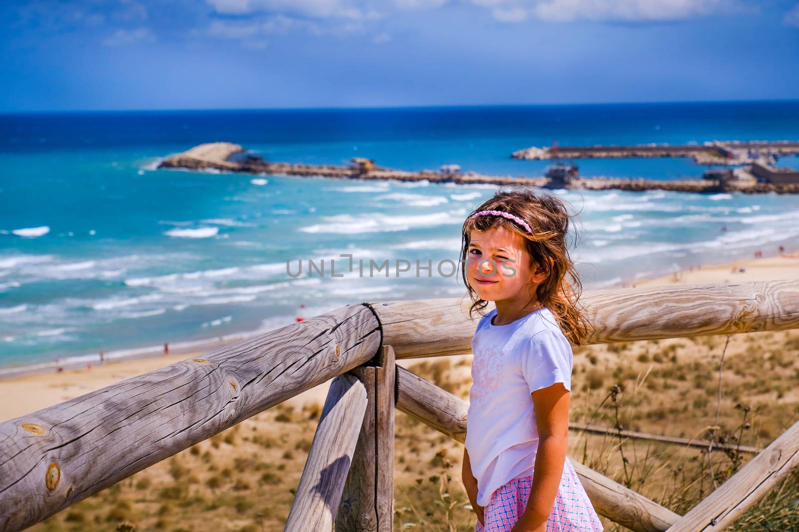 cute sweet nice smart look brat little girl baby wink with colorful summer seascape background by LucaLorenzelli