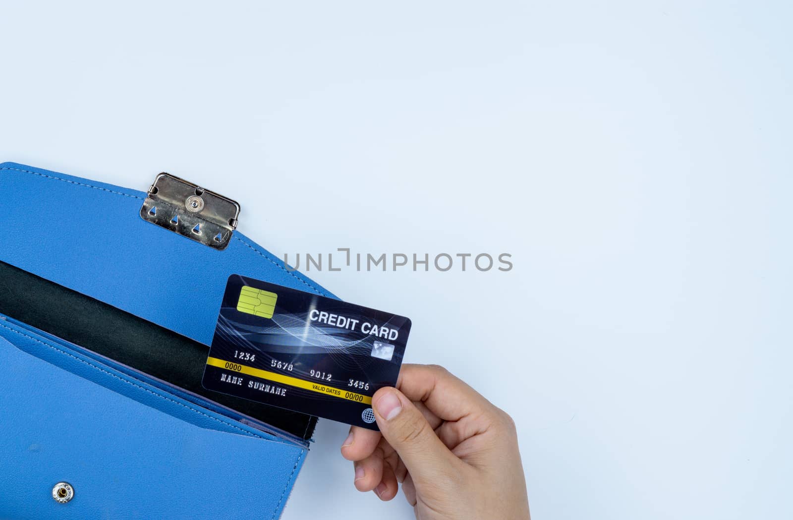 Woman hand taking out the credit card from blue purse for payment on the white background. Finance and money concept, top view, copy space for text.