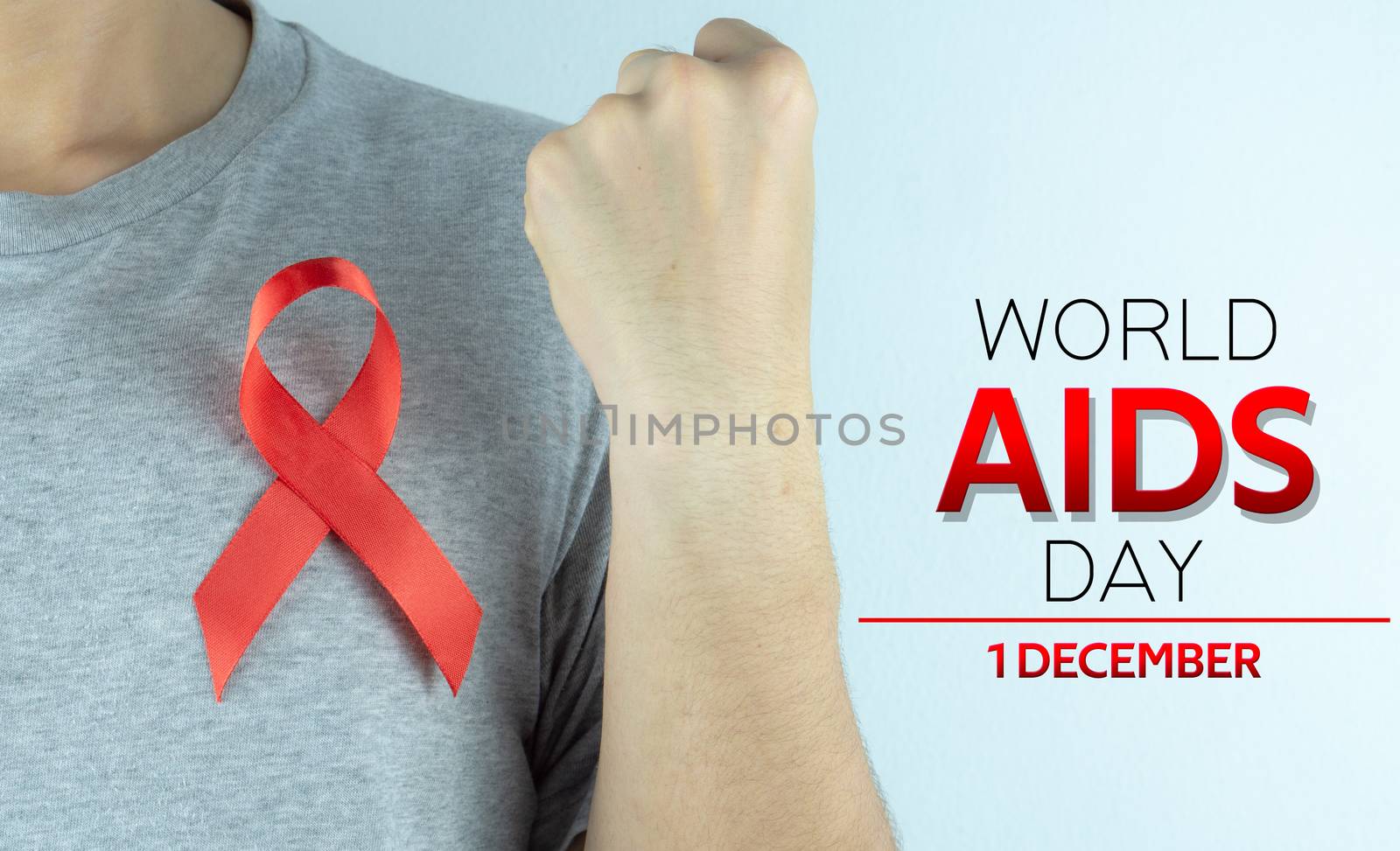 Aids awareness, male hands holding red AIDS awareness ribbon. Wo by mikesaran