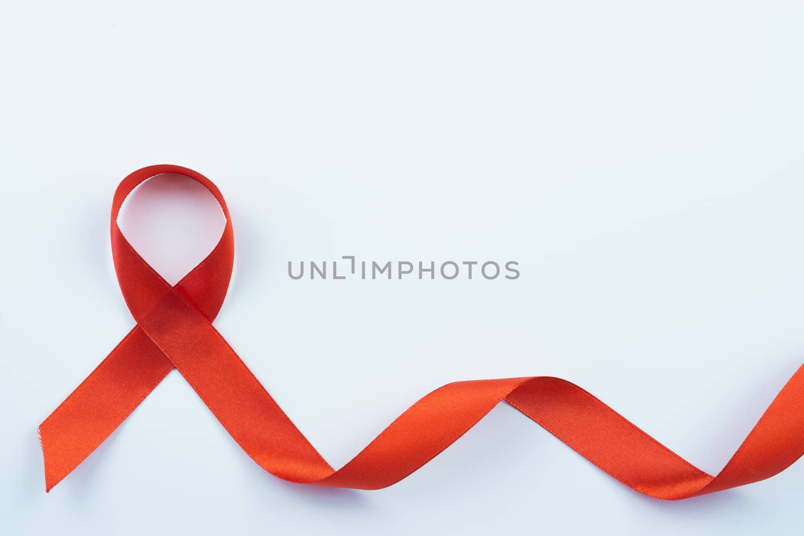 Aids awareness, red ribbon on white background with copy space f by mikesaran