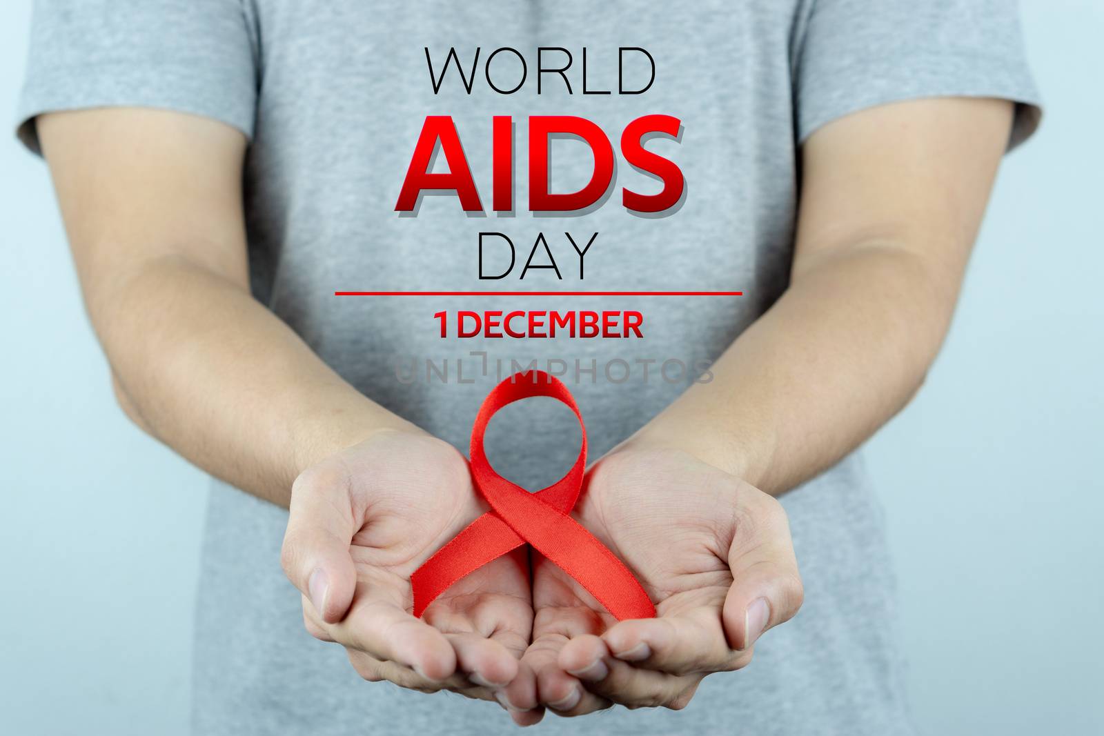 Aids awareness, male hands holding red AIDS awareness ribbon. World Aids Day, Healthcare and medical concept.