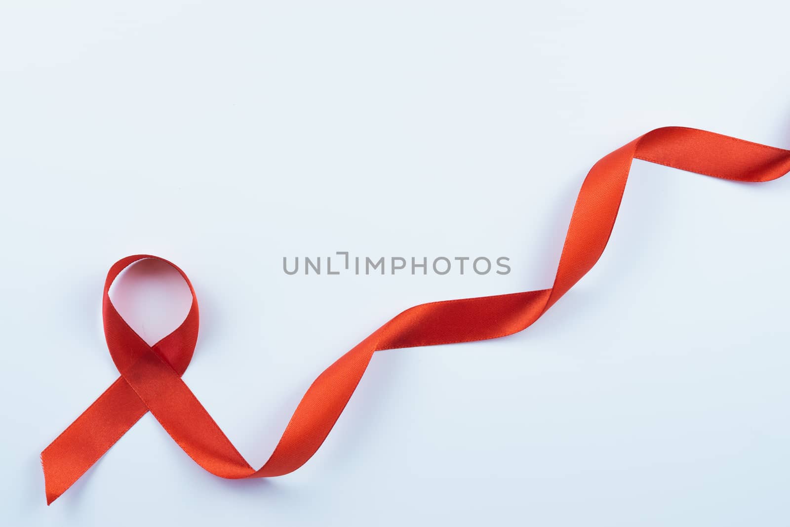 Aids awareness, red ribbon on white background with copy space f by mikesaran