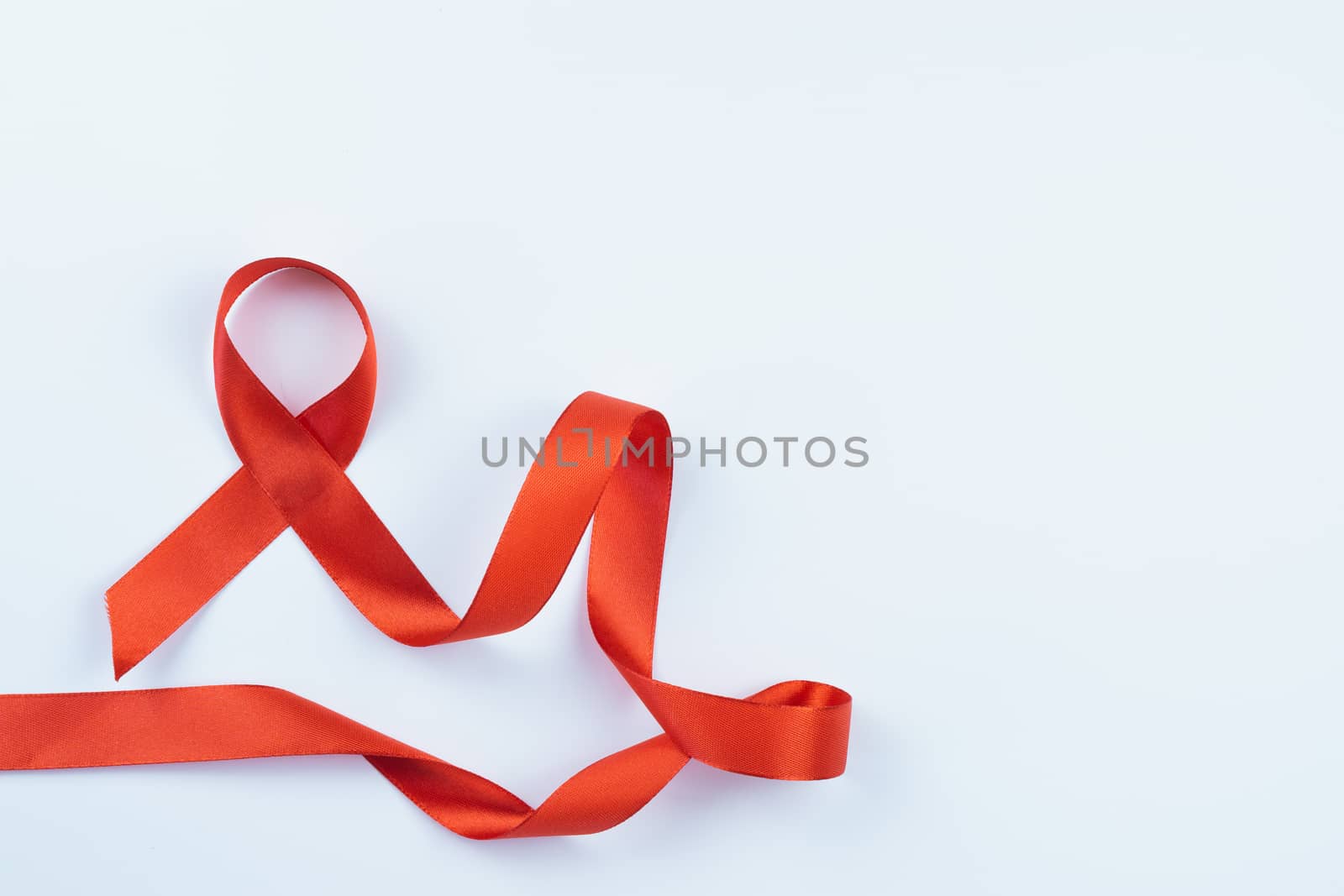 Aids awareness, red ribbon on white background with copy space f by mikesaran