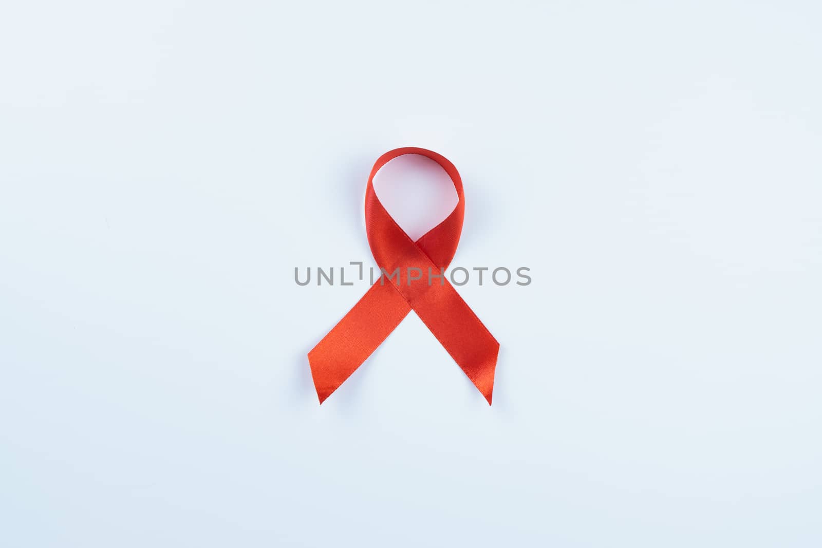 Aids awareness, red ribbon on white background with copy space f by mikesaran