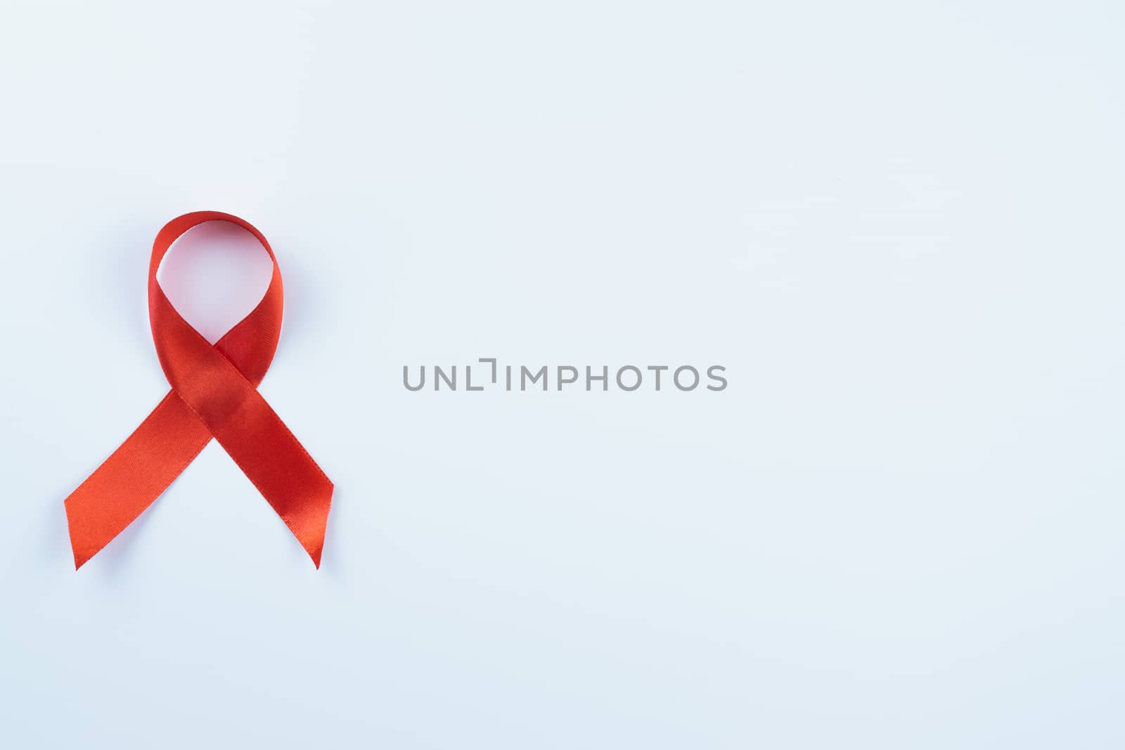 Aids awareness, red ribbon on white background with copy space f by mikesaran