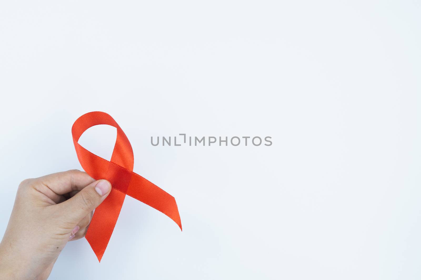 Aids awareness, male hands holding red AIDS awareness ribbon on white background. World Aids Day, Healthcare and medical concept.