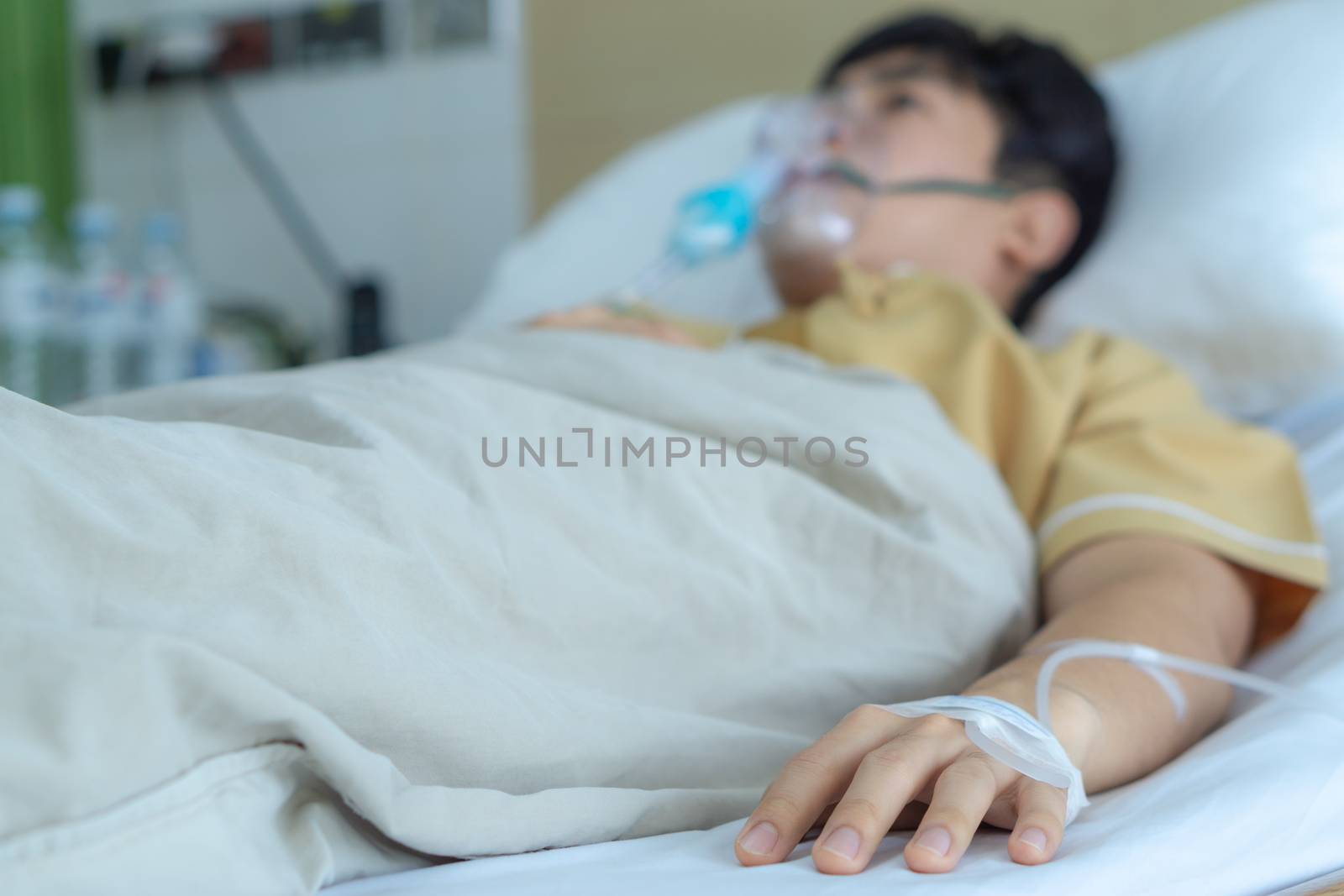 Patient hand with the tube of normal saline infusion at the hospital. Sick and health concept