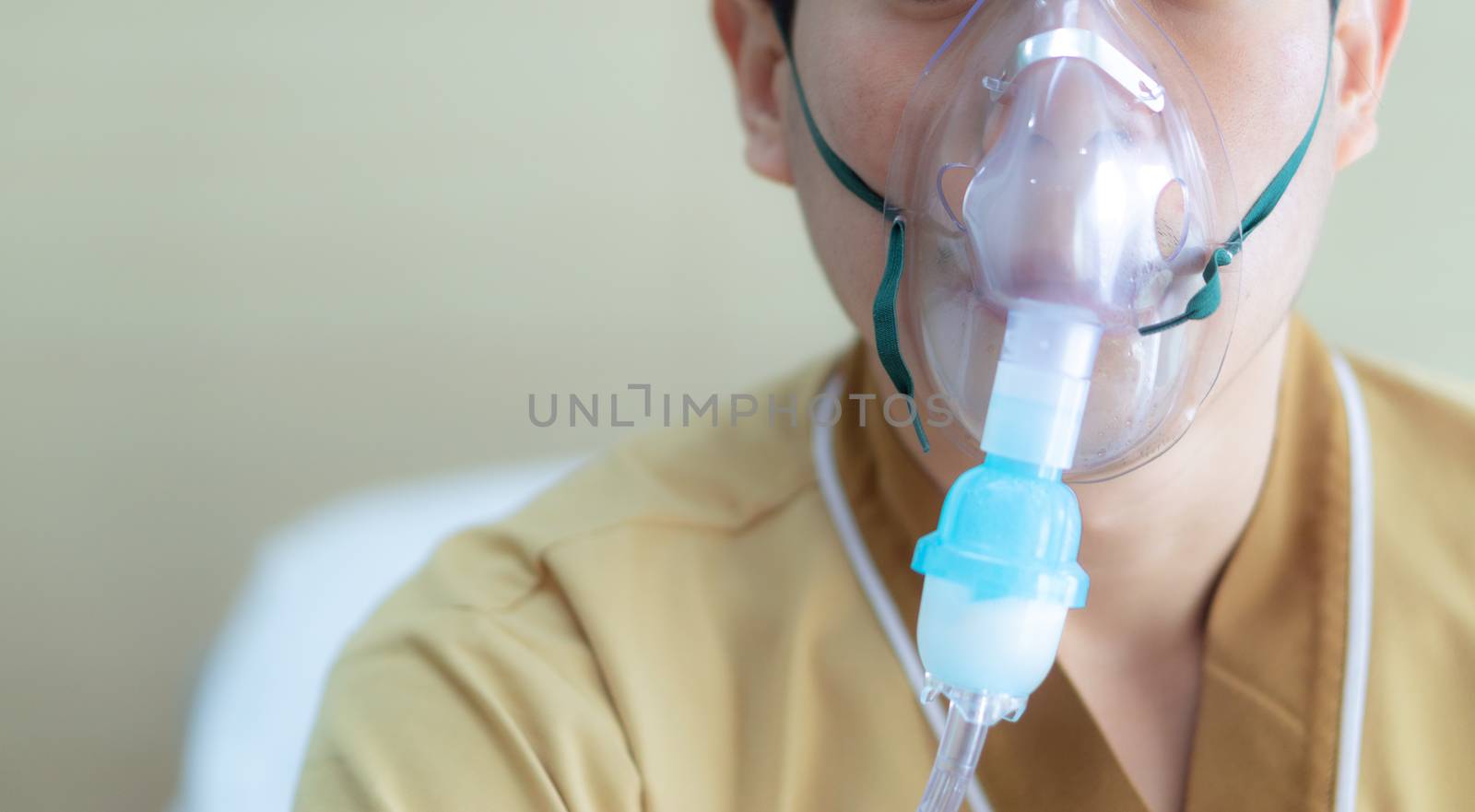 Young man making inhalation with nebulizer at the hospital. child asthma inhaler inhalation nebulizer steam. Sick cough and health concept