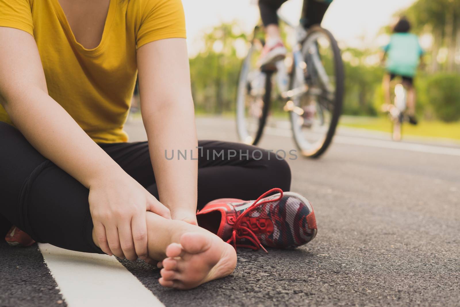 Ankle sprained. Young woman suffering from an ankle injury while jogging and running at the park. Healthcare and sport concept.