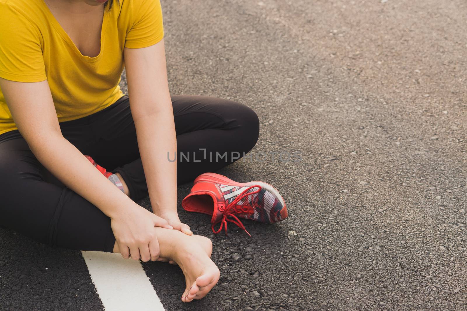 Ankle sprained. Young woman suffering from an ankle injury while by mikesaran