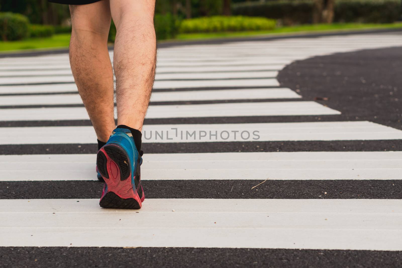 Closeup shoe. Male legs walking on the zebra crossing track. Safety road crossing concept