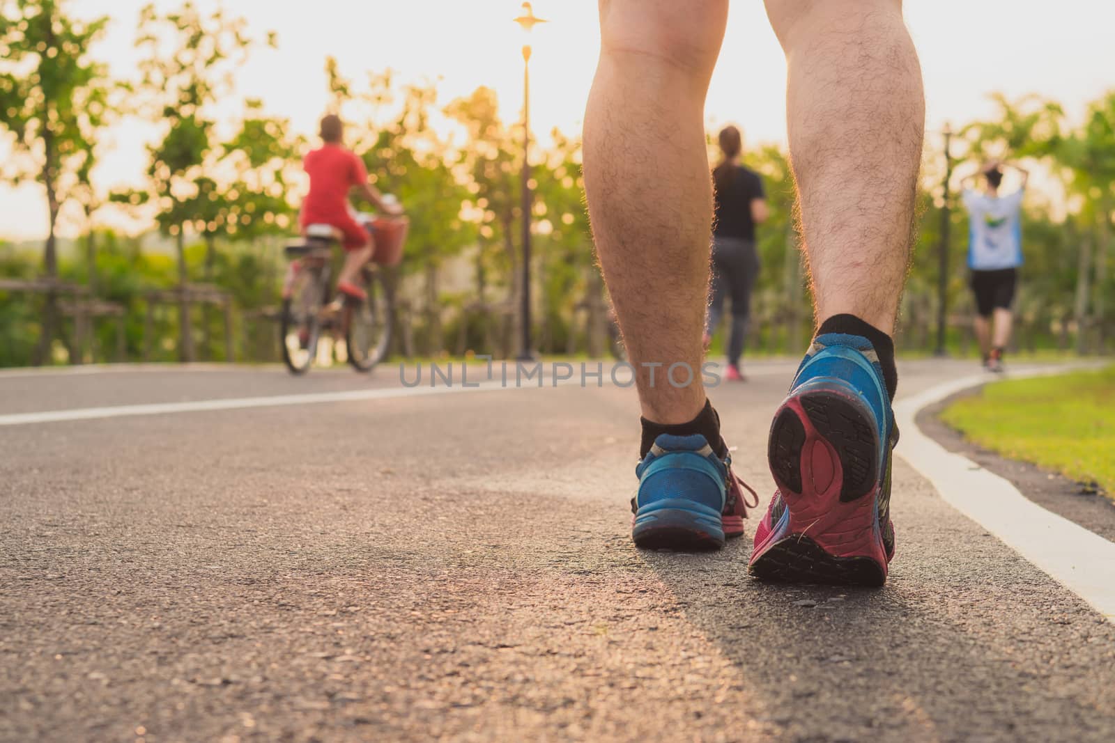 Closeup shoe. Male legs jogging and walking on the running track at the park. Sport and exercise concept