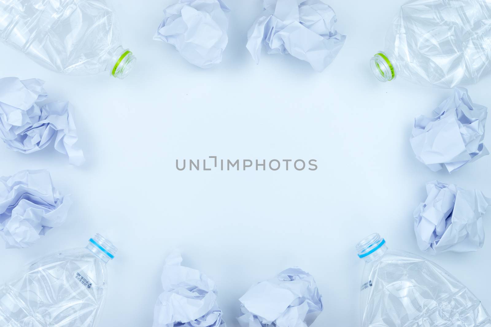 Recycling. The frame of used plastic bottle and crumpled paper on white background with copy space. Recycle and reuse concept