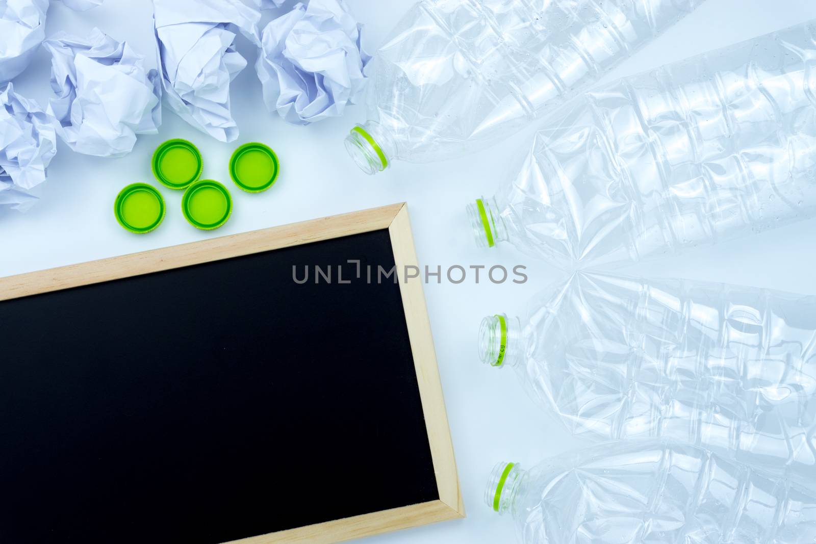 Recycling. The frame of used plastic bottle, blackboard and crumpled paper on white background with copy space. Recycle and reuse concept
