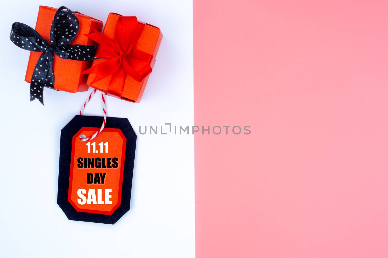 Online shopping of China, The Christmas boxes with red ribbon and shopping tag on a white and pink background with copy space for text. 11.11 single's day sale concept